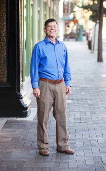 Single transgender man in blue shirt outside in urban setting