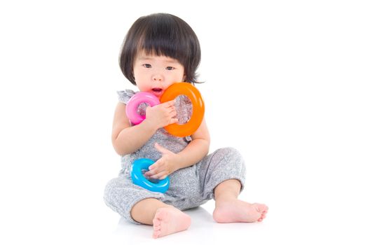 Cute asian girl sitting on the floor and playing toy