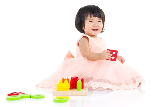 Cute asian girl sitting on the floor and playing toy