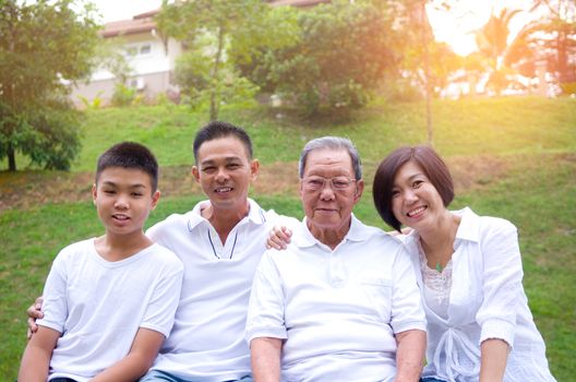 Portrait Of Multi-Generation Chinese Family Relaxing In Park Together