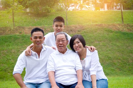 Portrait Of Multi-Generation Chinese Family Relaxing In Park Together