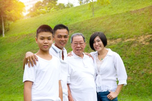 Portrait Of Multi-Generation Chinese Family Relaxing In Park Together