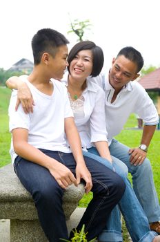 Asian Chinese Family Relaxing In Park 