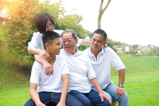 Portrait Of Multi-Generation Chinese Family Relaxing In Park 