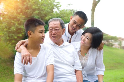 Portrait Of Multi-Generation Chinese Family Relaxing In Park 