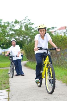 Asian Family On Cycle Ride In Countryside