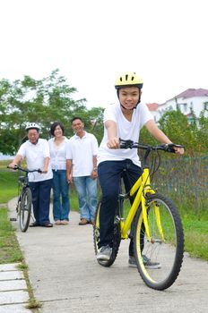 Asian three generation Family On Cycle Ride In Countryside