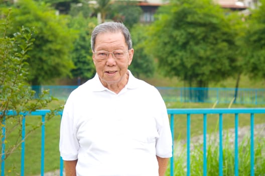 Portrait of a smiling asian senior man at outdoor park