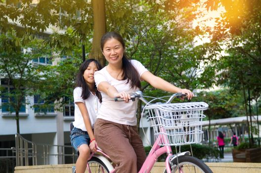 Mother and a daughter cycling bicycle at the park