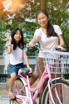 Mother and a daughter cycling bicycle at the park