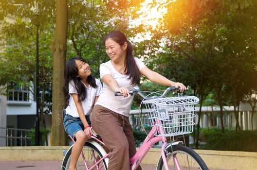 Mother and a daughter cycling bicycle at the park