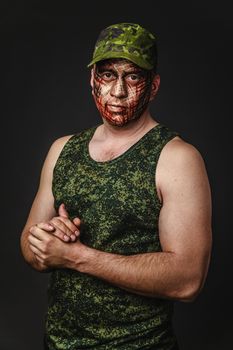 Portrait of Brutal Man with Creative Military Style Camouflage. Face Paint.  Close up on black background