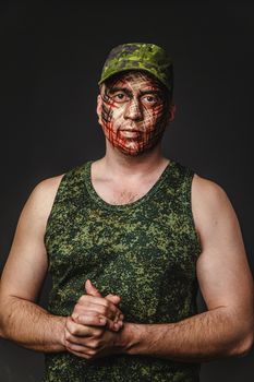 Portrait of Brutal Man with Creative Military Style Camouflage. Face Paint.  Close up on black background