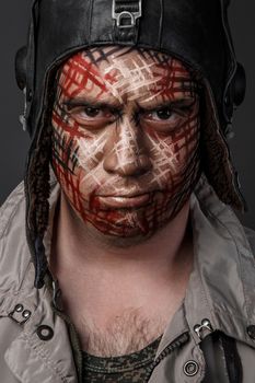 Portrait of Brutal Man with Creative Military Style Camouflage. Face Paint.  Close up on black background