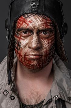 Portrait of Brutal Man with Creative Military Style Camouflage. Face Paint.  Close up on black background