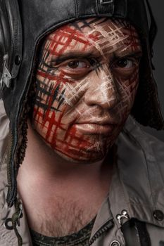 Portrait of Brutal Man with Creative Military Style Camouflage. Face Paint.  Close up on black background