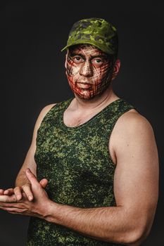 Portrait of Brutal Man with Creative Military Style Camouflage. Face Paint.  Close up on black background