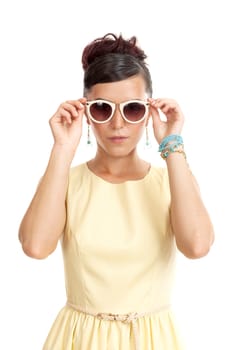 the young woman in sunglasses and in a light dress on a white background