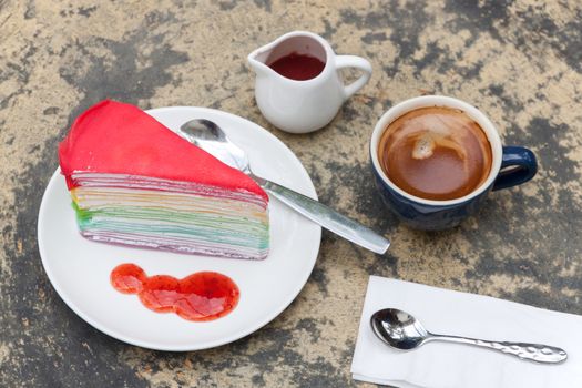 crape cake rainbow and hot espresso coffee in garden side home. crape cake with strawberry sauce