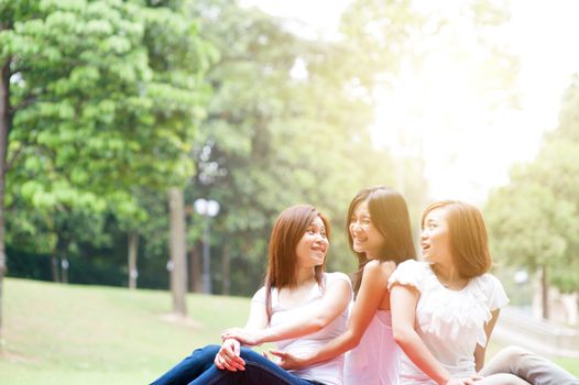 Group of Asian women having fun at outdoor park, sisters or girlfriends, friendship concept, sun flare background.