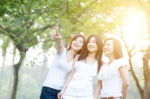 Group of young Asian women having fun at outdoor park, sisters or girlfriends, friendship concept, sun flare background.