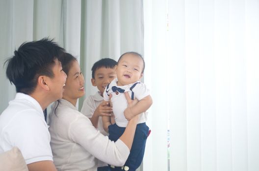 Asian family playing with baby