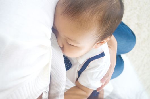 Asian mother breastfeeding her baby boy