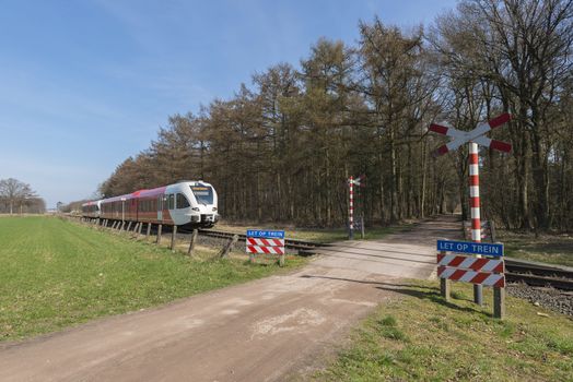 Unguarded, light rail railway crossing without barriers and warning lights in the East of the Netherlands
