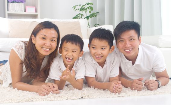 Asian family lying on the floor and smiling