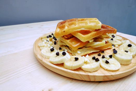 Waffle with Chocolate Chip and Banana on the Table Wooden