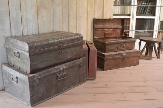 Old scrap boxes on a wooden floor with a suitcase