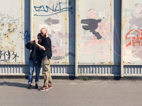 Kiev, Ukraine - April 04, 2017: Happy couple taking a picture on a wall background with graffiti