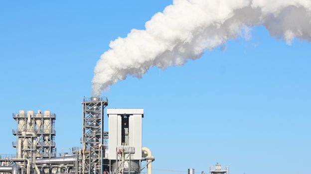 White smoke from the chimney on blue sky background. Industry factory environment ecology pollution