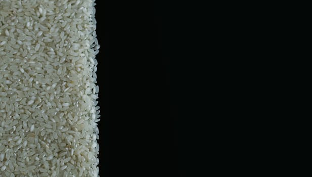 Rice spill left on black background. Agriculture food raw seed. Closeup macro photo
