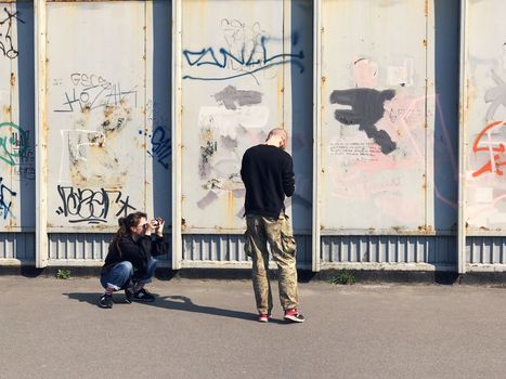 Happy couple taking a picture on a wall background with graffiti