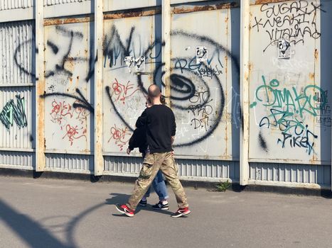 Happy couple taking a picture on a wall background with graffiti