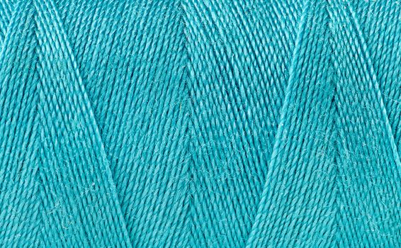 Abstract background blue thread spooled on a bobbin
