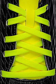Closeup of yellow laces on black sneakers