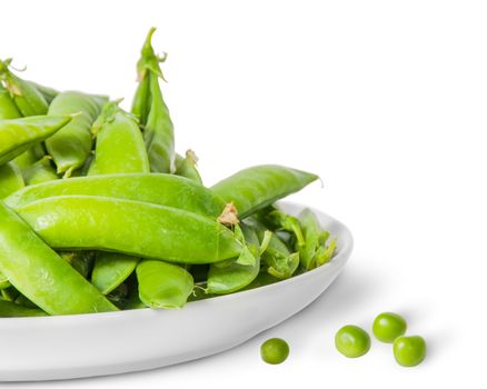 Closeup pile of green peas in pods in white plate isolated on white background