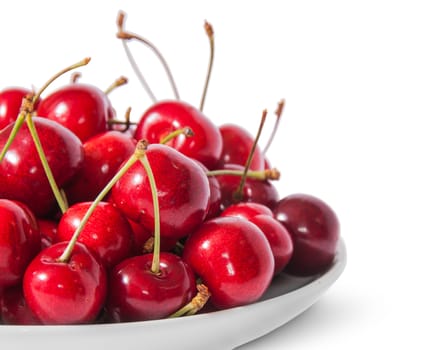 Closeup red sweet cherries in white plate isolated on white background