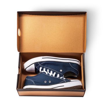 Dark blue sports shoes inside cardboard box isolated on white background