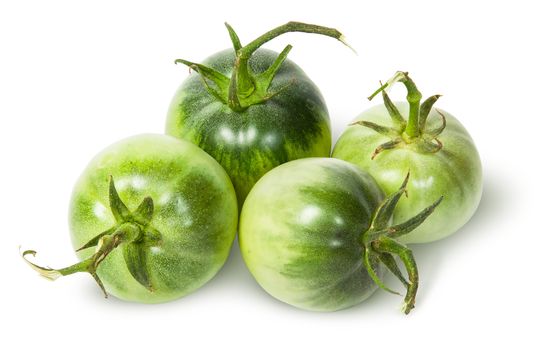 Four green tomatoes near isolated on white background