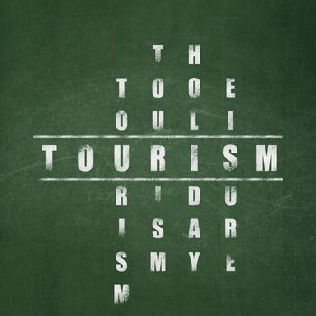 Travel concept: Painted White word Tourism in solving Crossword Puzzle on School board background, School Board