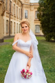 Stylish bride in a white wedding dress in summer day