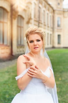 Stylish bride in a white wedding dress in summer day