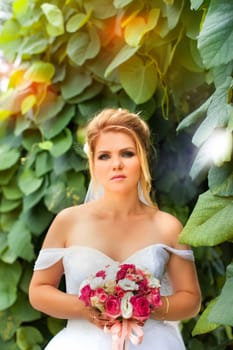 Stylish bride in a white wedding dress in summer day