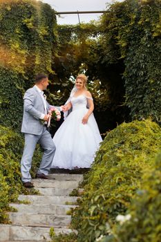 Newlyweds on a walk in the summer day wedding