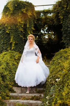 Stylish bride in a white wedding dress in summer day