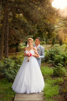 Newlyweds on a walk in the summer day wedding