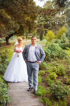 Newlyweds on a walk in the summer day wedding